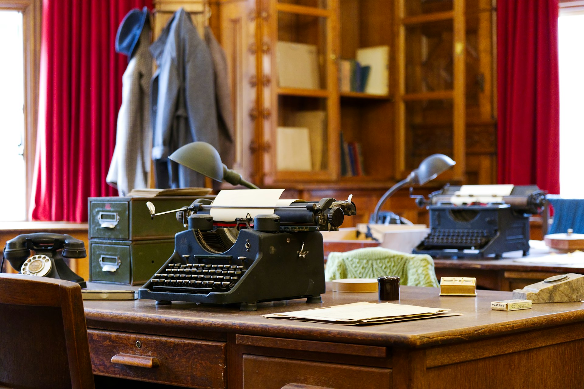 An old fashioned desk with a typewriter on it